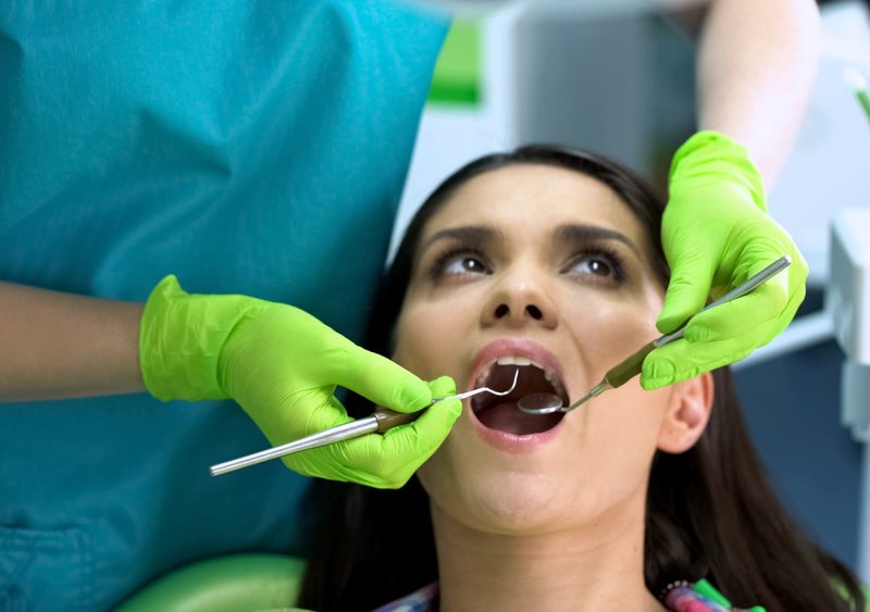 Dentist checking female patient teeth, oral cavity health, regular checkup