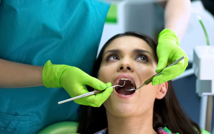 Dentist checking female patient teeth, oral cavity health, regular checkup