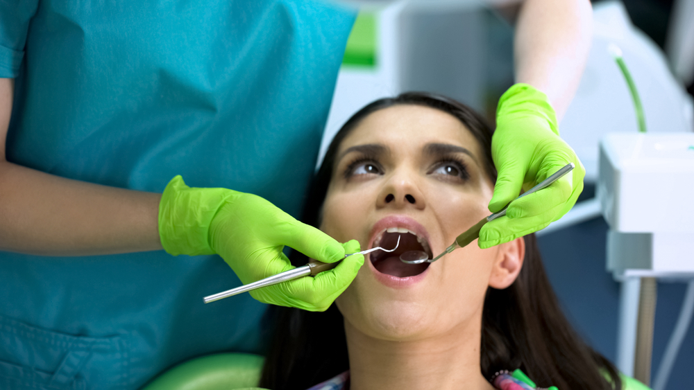 Dentist checking female patient teeth, oral cavity health, regular checkup