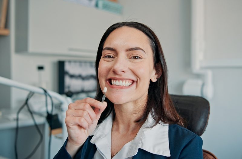 Happy woman, portrait or patient in dental clinic for crown, veneers or medical procedure. Appointment, smile or person with implant in oral exam for dentistry, teeth whitening or cosmetics treatment