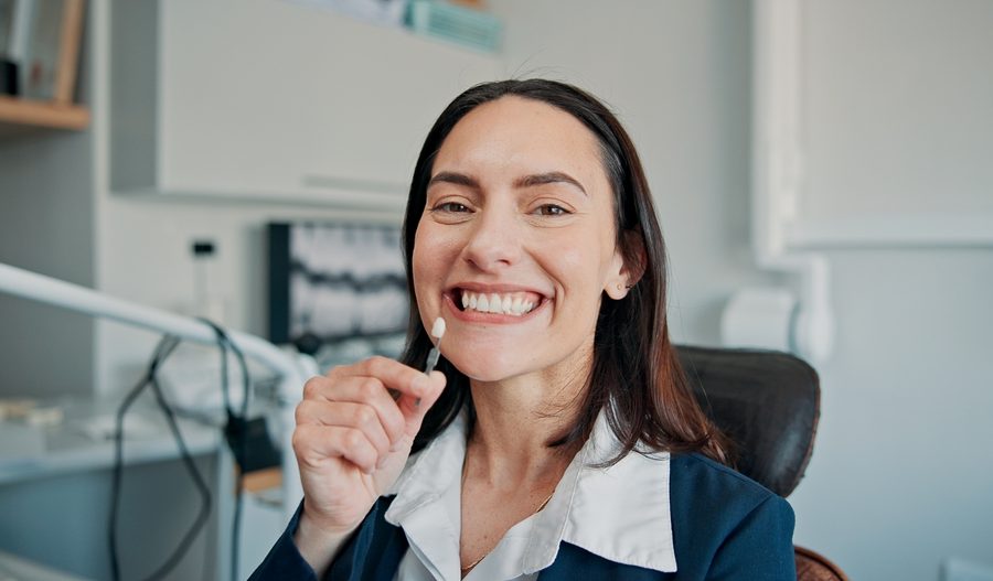 Happy woman, portrait or patient in dental clinic for crown, veneers or medical procedure. Appointment, smile or person with implant in oral exam for dentistry, teeth whitening or cosmetics treatment
